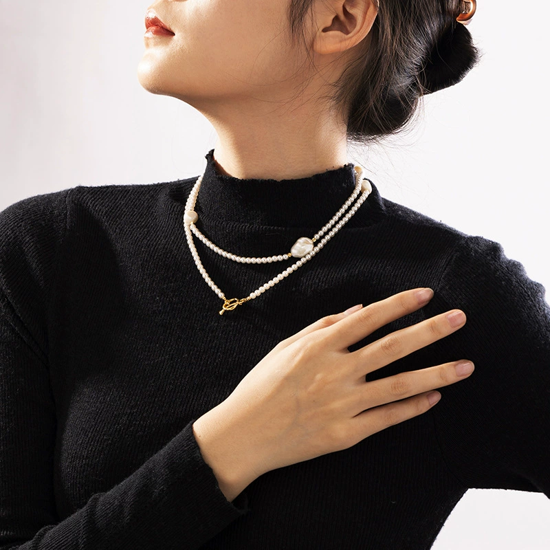 LIVKE’s irregular freshwater pearl necklace on a gold chain, styled with a beige sweater for minimalist everyday elegance.