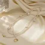 LIVKE’s irregular freshwater pearl necklace on a gold chain, styled with a beige sweater for minimalist everyday elegance.
