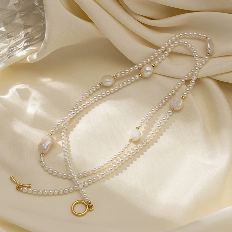 LIVKE’s irregular freshwater pearl necklace on a gold chain, styled with a beige sweater for minimalist everyday elegance.