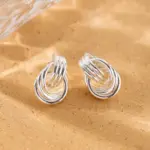 LIVKE’s silver geometric hoop earrings with triple coil layers, styled with a sleek bun for minimalist office elegance.