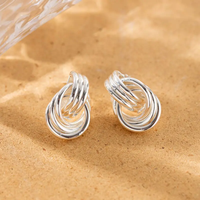 LIVKE’s silver geometric hoop earrings with triple coil layers, styled with a sleek bun for minimalist office elegance.