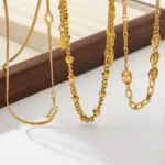 Three LIVKE gold layered necklaces with minimalist pendants, styled over a white tee for casual-chic everyday outfits.