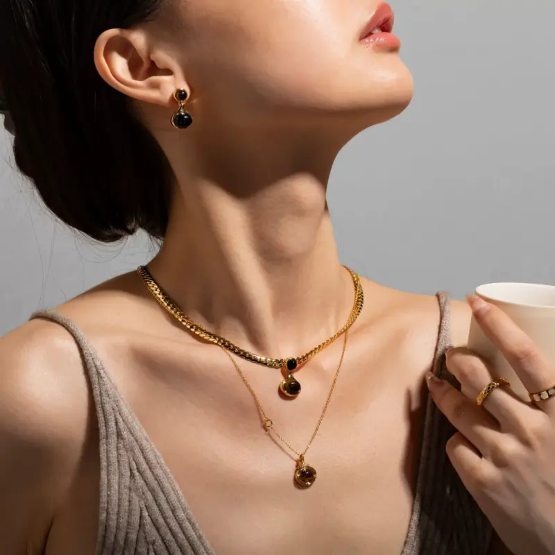 LIVKE’s gold tiger eye oval pendant on a snake chain, styled with a linen dress for boho-chic everyday elegance.