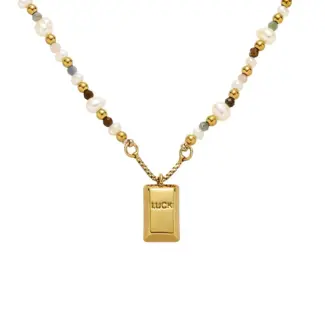 LIVKE’s gold French vintage ‘Luck’ pendant necklace with pearl drop, styled with a white blouse for office elegance.
