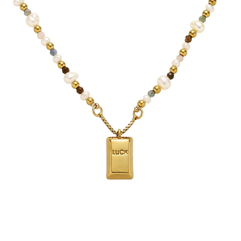 LIVKE’s gold French vintage ‘Luck’ pendant necklace with pearl drop, styled with a white blouse for office elegance.