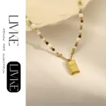 LIVKE’s gold French vintage ‘Luck’ pendant necklace with pearl drop, styled with a white blouse for office elegance.