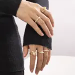Vintage freshwater pearl set in 18K gold filigree band, styled with lace gloves for bridal elegance.