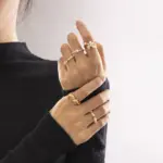 Vintage freshwater pearl set in 18K gold filigree band, styled with lace gloves for bridal elegance.
