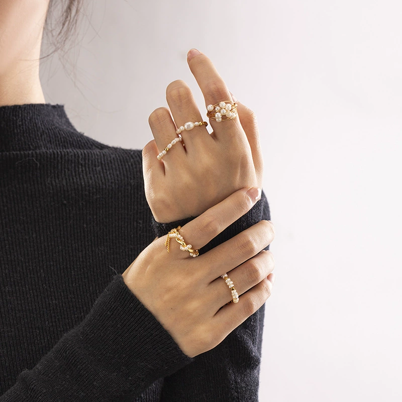 Vintage freshwater pearl set in 18K gold filigree band, styled with lace gloves for bridal elegance.