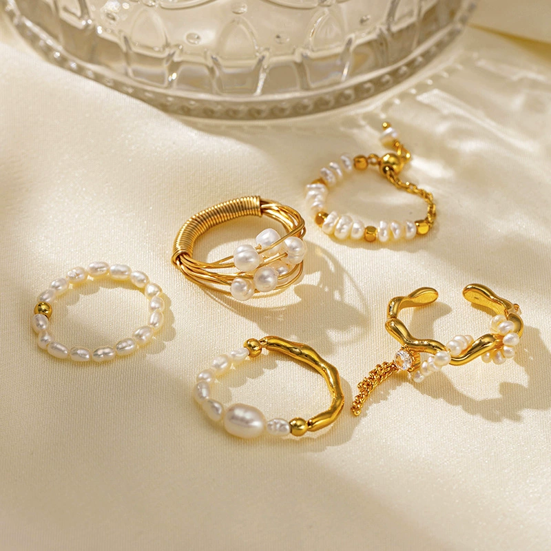 Vintage freshwater pearl set in 18K gold filigree band, styled with lace gloves for bridal elegance.