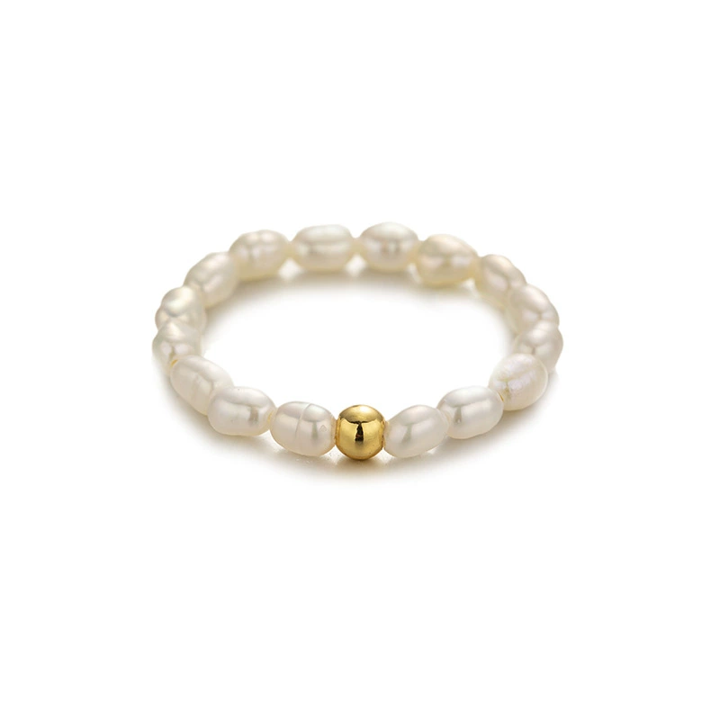 Vintage freshwater pearl set in 18K gold filigree band, styled with lace gloves for bridal elegance.