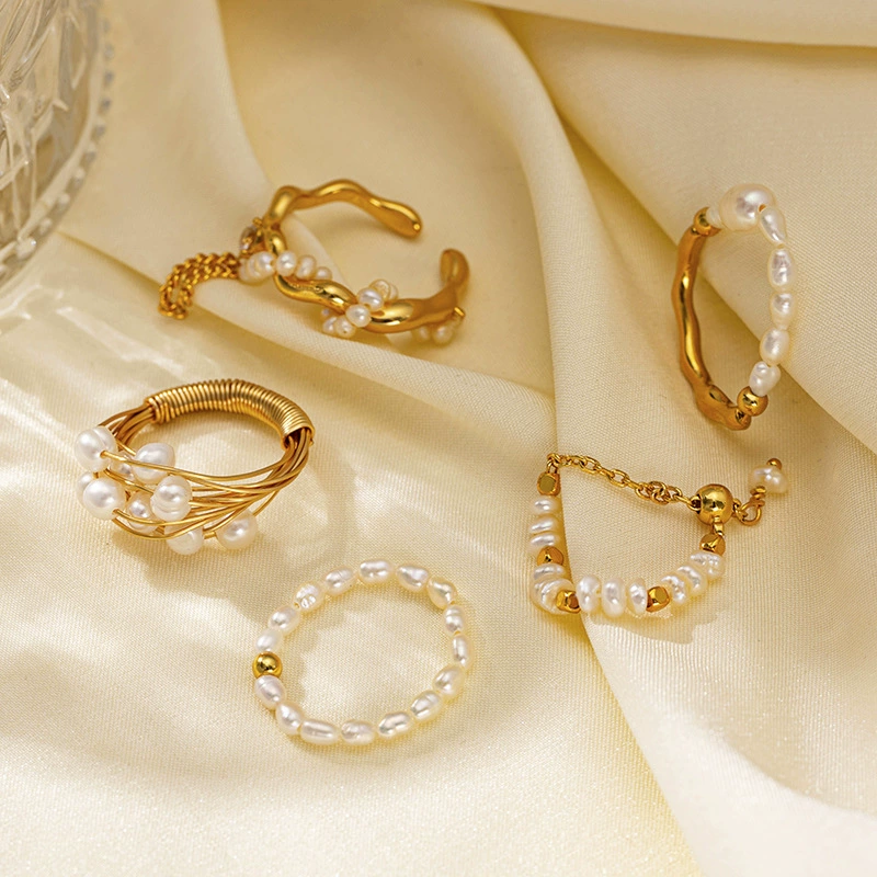 Vintage freshwater pearl set in 18K gold filigree band, styled with lace gloves for bridal elegance.