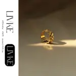 LIVKE’s gold gear ring on a hand with black polish, styled with a leather jacket for urban minimalist edge.