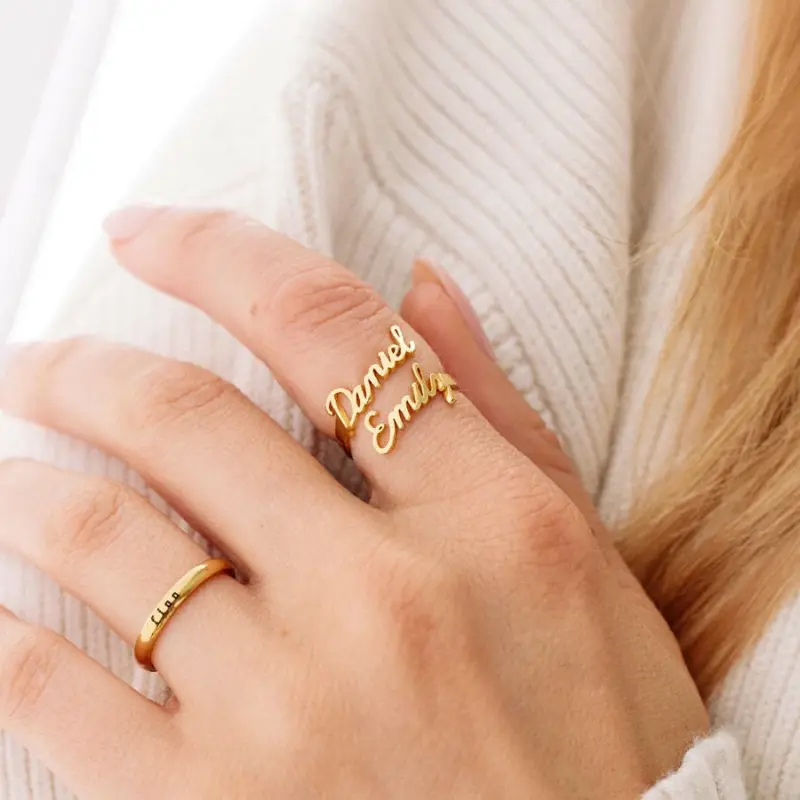 Personalized open-ended couple rings with engraved names "Alex & Sam" in 18K gold.