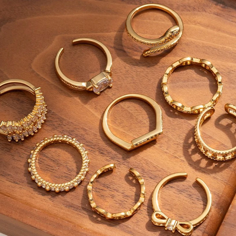 Eclectic woman stacking LIVKE gold textured rings on fingers while browsing vintage market, showcasing bohemian jewelry styling