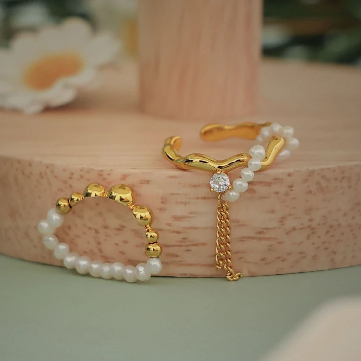 Hand wearing LIVKE adjustable pearl tassel ring at desert festival, showcasing boho jewelry with flowing movement
