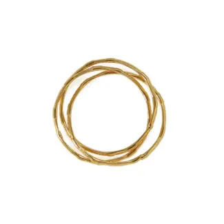 Three layered brass rings with spiral/chain/wave designs in 18K gold plating, stacked on a wooden tray for boho style