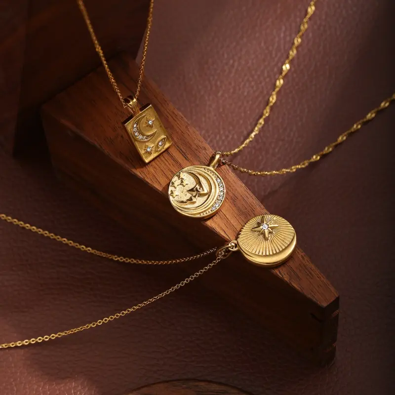 Gold sun and moon pendants layered on model with white linen shirt