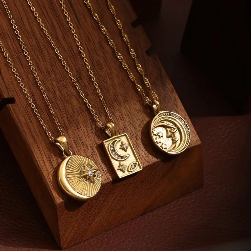 Gold sun and moon pendants layered on model with white linen shirt