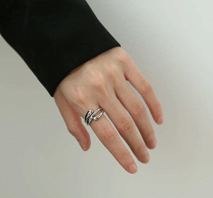 Architect wearing LIVKE geometric ring with concrete maquette in Berlin gallery, demonstrating jewelry as micro-architecture