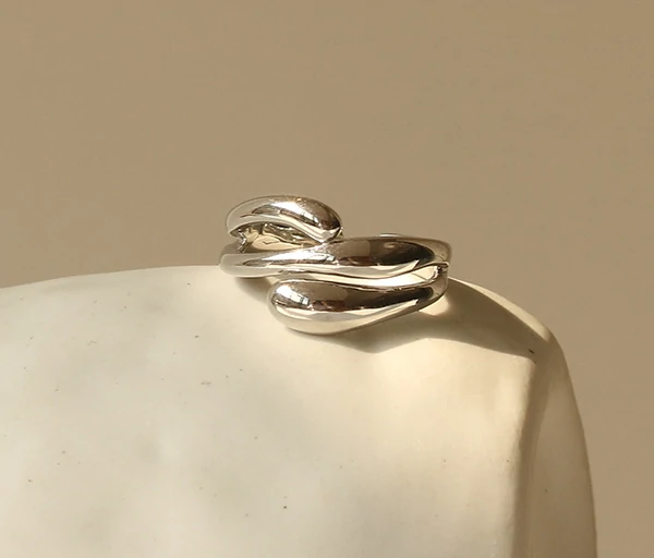 Architect wearing LIVKE geometric ring with concrete maquette in Berlin gallery, demonstrating jewelry as micro-architecture