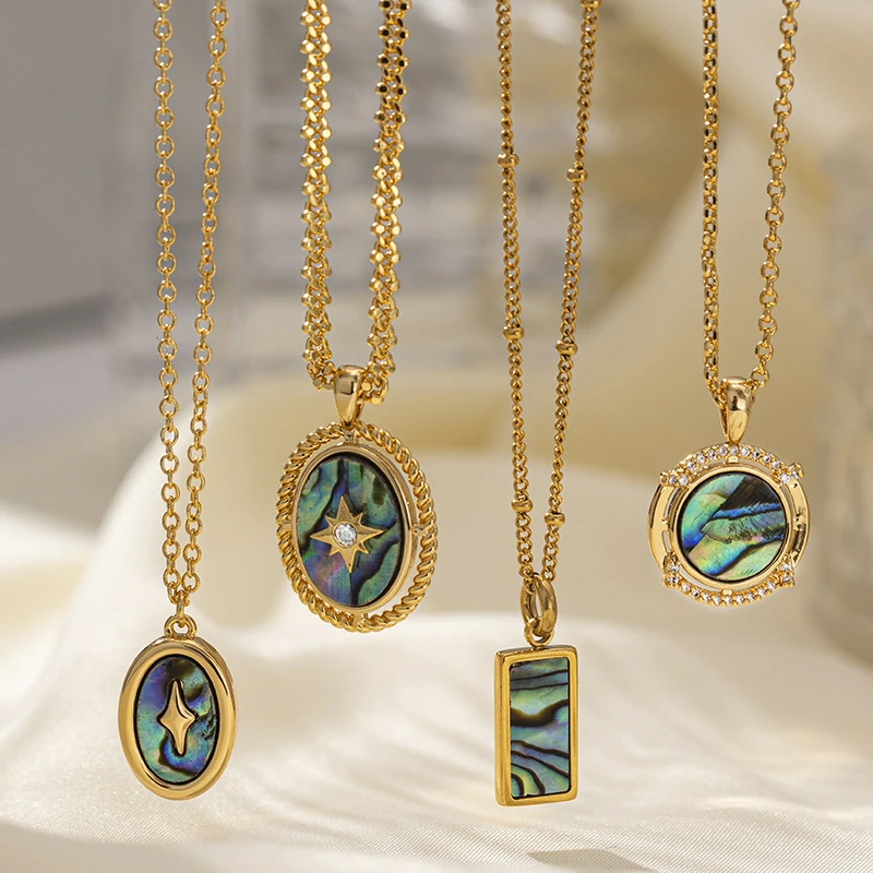 Layered oceanic necklaces on sand with seashells under sunset light
