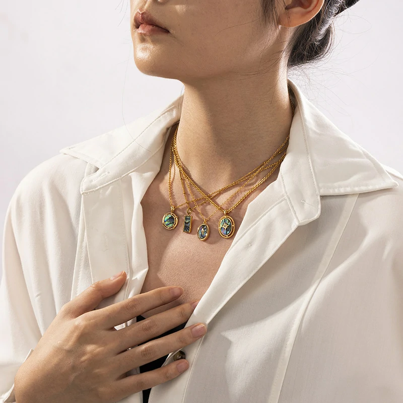 Layered oceanic necklaces on sand with seashells under sunset light