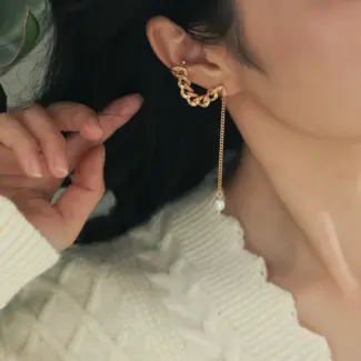 Model turning head to showcase flowing pearl tassels catching sunlight