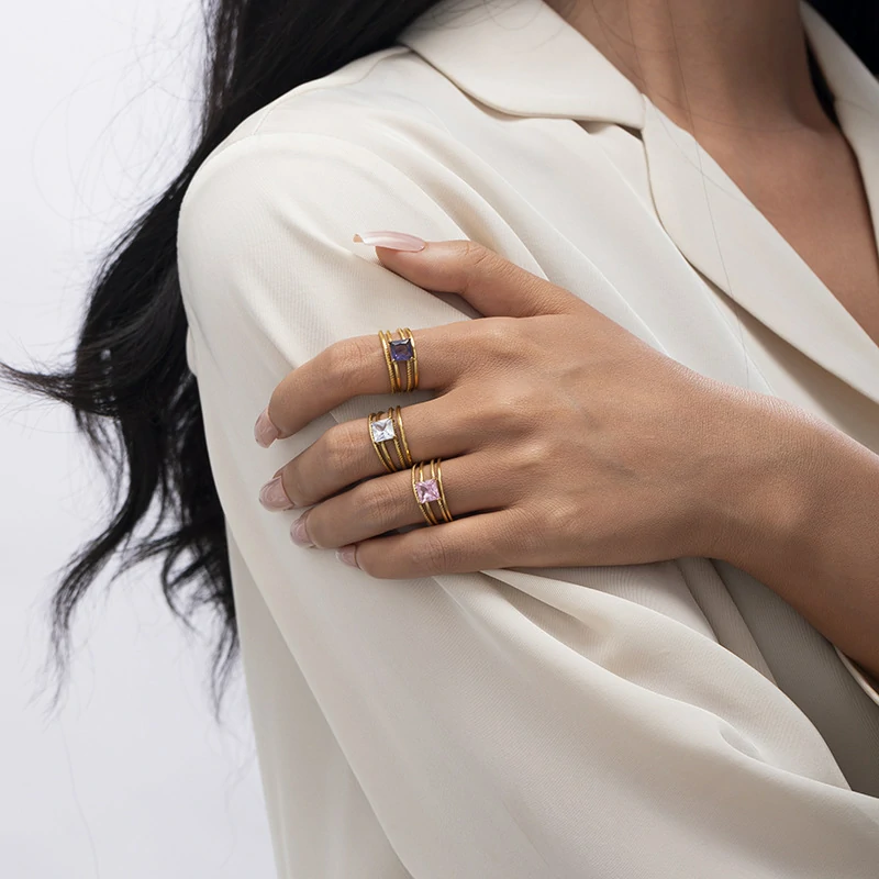 Stacked LIVKE open rings in lavender, clear and deep purple CZ on manicured hand