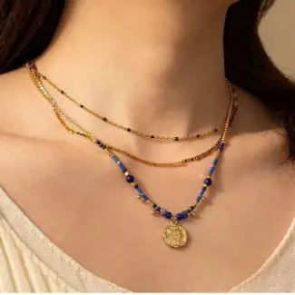 LIVKE’s gold-plated brass necklace featuring a lapis lazuli pendant, styled with a white linen blouse for effortless elegance.