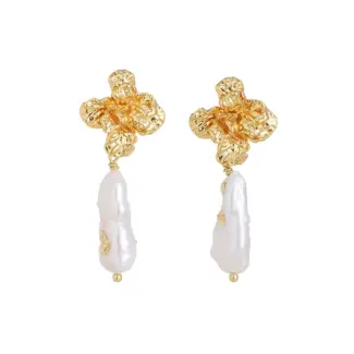 Woman wearing LIVKE vintage pearl earrings with a black evening dress, golden flowers and baroque pearls reflect the vintage luster under candlelight