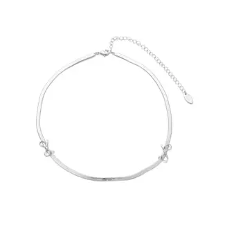 Bride wearing LIVKE white gold bow necklace with off-shoulder wedding dress, showcasing elegant bridal jewelry under sunset light