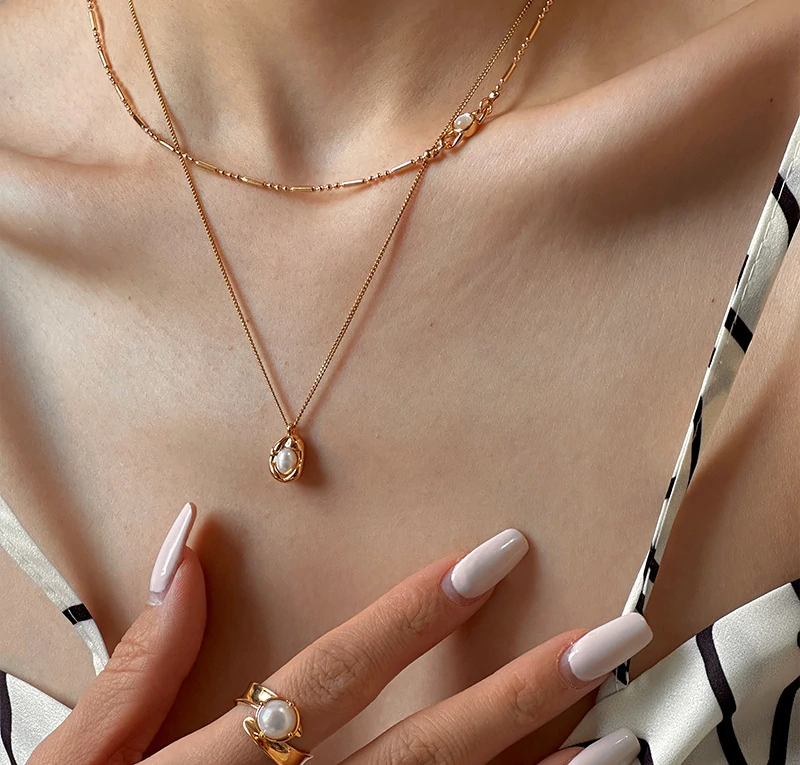 Delicate gold and silver chain set with iridescent shell pendants, perfect for beach weddings and minimalist jewelry lovers